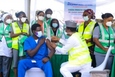 Dr. Ngong Cyprian (L), o primeiro nigeriano a receber a primeira dose da vacina Oxford/AstraZeneca no Hospital Nacional de Abuja, Nigéria