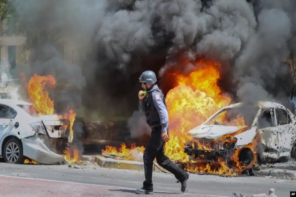 Um bombeiro israelita caminha perto de carros atingidos por um míssil disparado da Faixa de Gaza, na cidade israelita de Ashkelon, terça-feira, 11 de Maio de 2021.