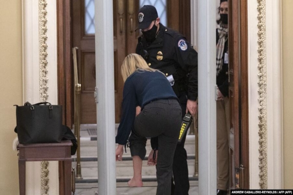 Congressista republicana Marjorie Greene tira os sapatos ao passar a segurança à entrada do COngresso em Washington, 12 Janeiro 2021