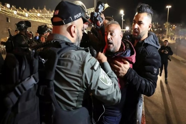 Confronto entre um polícia israelita e um homem com uma máquina fotográfica junto à entrada do bairro muçulmano da Cidade Santa de Jerusalém, na noite de 22 de Abril de 2021. REUTERS - AMMAR AWAD