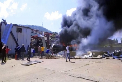 Os residentes de Mekele assistem ao incêndio de uma fábrica de automóveis.